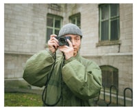a man holding a camera in front of a building
